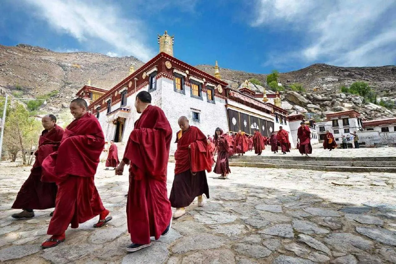 Buddhista szerzetesek tibeti kolostornál ázsiai körutazáson