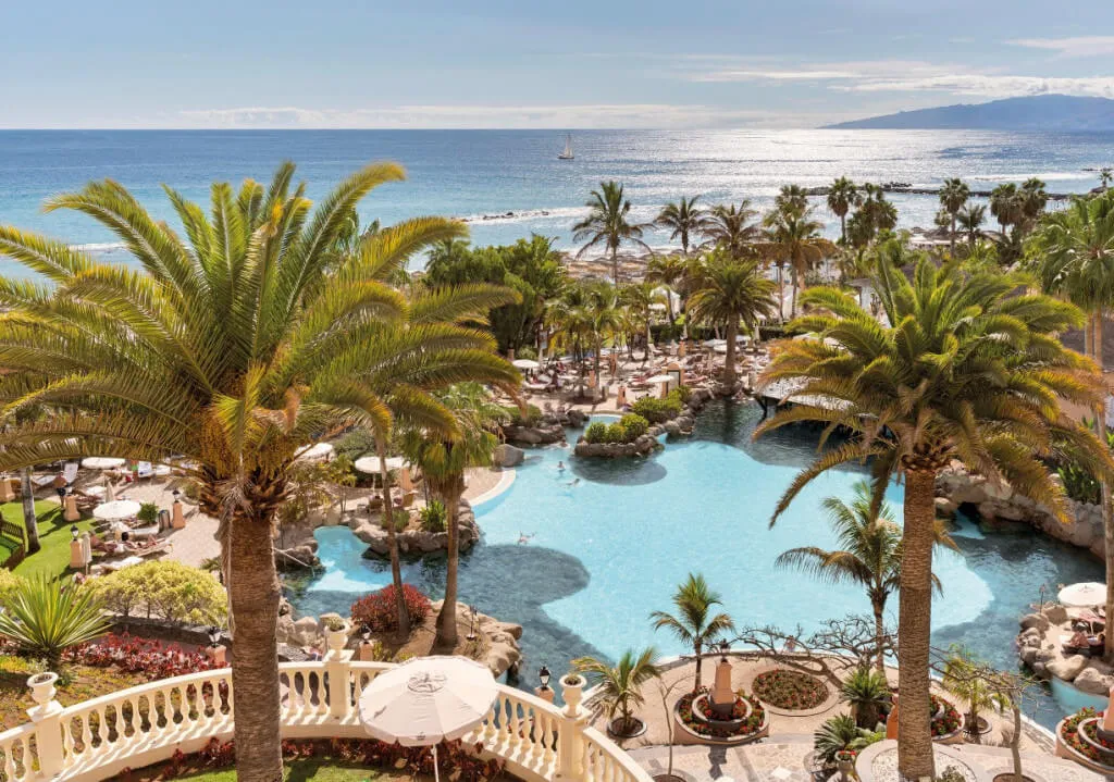 Tenerife óceánparti szállodája medencével és pálmákkal
